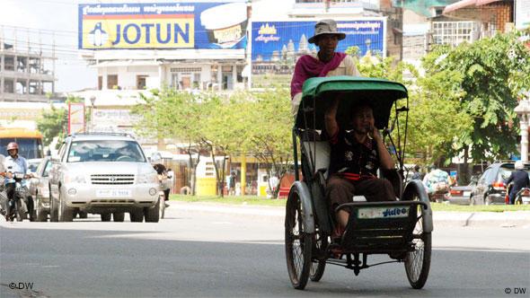 A Cambodian girl is sqeezed between a driver and a passenger of an  overloaded motorbike taxi in the capital Phnom Penh, Tuesday, April 4,  2006. Overloaded motorcycles and cars are a common