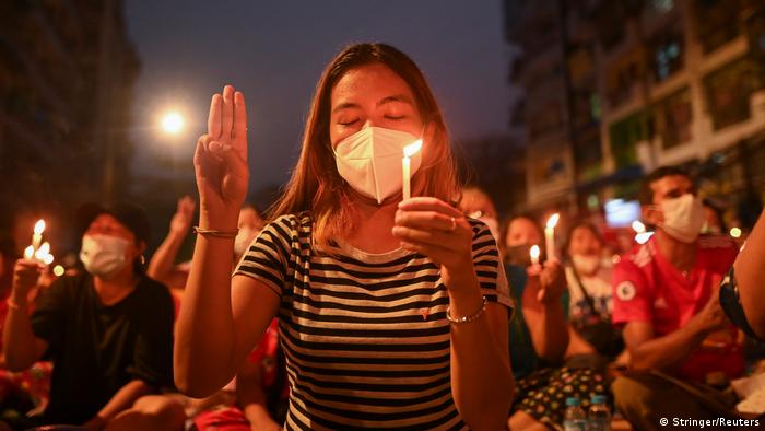 A woman holds a candle during an anti-coup night protest in Yangon, Myanmar, March 14, 2021.