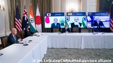 From left to right at the table: United States President Joe Biden, US Secretary of State Antony Blinken, Counselor to the President Jeffrey Zients, and Sumona Guha, Senior Director for South Asia, National Security Council (NSC)meet virtually with their counterparts in the Quad, from left to right on the monitors, Prime Minister Yoshihide Suga of Japan, Prime Minister Narendra Modi of India, and Prime Minister Scott Morrison of Australia, and , from the State Dining Room of the White House in Washington DC, USA, 12 March 2021. Credit: Jim LoScalzo / Pool via CNP/AdMedia