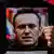 Мужчина держит портрет Алексея Навального на акции солидарности в Лиссабоне
