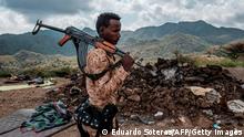 TOPSHOT - A member of the Afar Special Forces stands in front of the debris of a house in the outskirts of the village of Bisober, Tigray Region, Ethiopia, on December 09, 2020.Several houses in the village were damaged during the confrontations between the Tigray Forces and the Ethiopian Defense Forces. (Photo by EDUARDO SOTERAS / AFP) (Photo by EDUARDO SOTERAS/AFP via Getty Images)