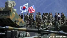(FILES) This file photo taken on April 26, 2017 shows South Korean and US soldiers watching from an observation post during a joint live firing drill between South Korea and the US at the Seungjin Fire Training Field in Pocheon, 65 kms northeast of Seoul. - South Korea and the United States have reached agreement on Seoul's contribution to the costs of the US troop presence on the peninsula, Seoul said on March 8, 2021 as the two allies kicked off annual joint military exercises. (Photo by JUNG Yeon-Je / AFP)