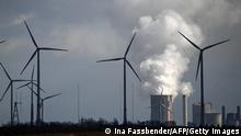 Wind turbines are seen near the coal-fired power station Neurath of German energy giant RWE in Garzweiler, western Germany, on March 15, 2021. - On March 16, 2021, the group will present its detailed figures for 2020, for the last time with RWE CEO Rolf Martin Schmitz. Despite the coronavirus pandemic, 2020 was a successful year for RWE. (Photo by INA FASSBENDER/AFP via Getty Images)