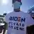 A Honduran man seeking asylum wearing a T-shirt reading "Biden please let us in"
