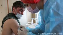 A man receives a dose of the Sputnik V (Gam-COVID-Vac) vaccine against the coronavirus disease (COVID-19) in a carriage of the Academician Fyodor Uglov medical train, at a railway station in the town of Tulun in Irkutsk Region, Russia March 16, 2021. REUTERS/Evgeny Kozyrev