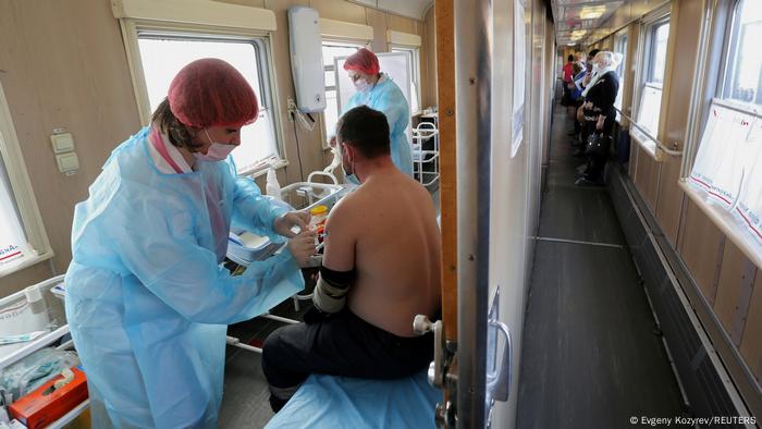 Медицинский работник водит мужчину в поезде