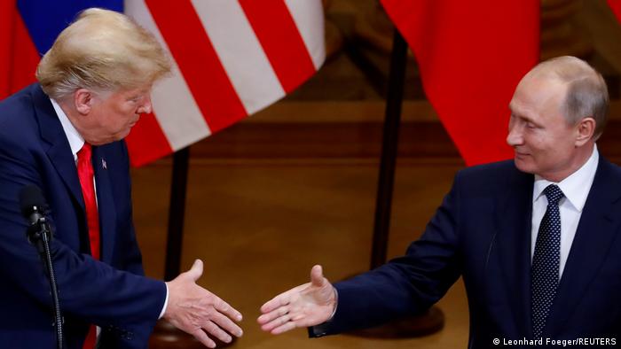 Former US President Donald Trump and Russian President Vladimir Putin shake hands at a joint news conference in Helsinki in July 2018