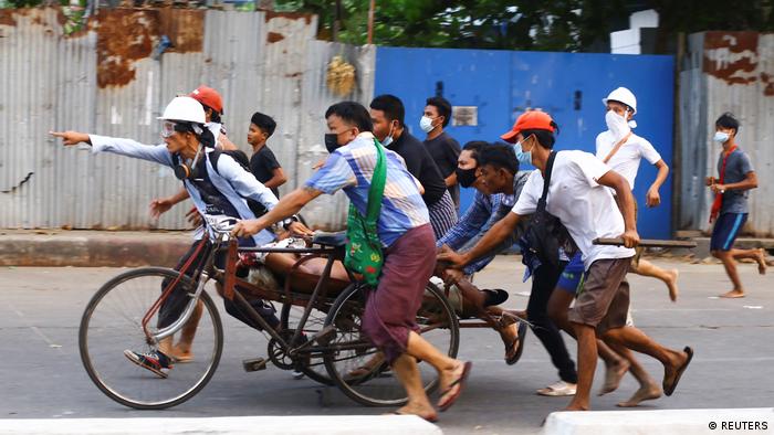 People transport a person who was shot during a security force crackdown on anti-coup protesters in Thingangyun, Yangon