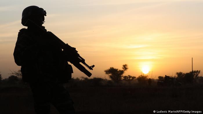  A soldier stands guard at sunset in Niamey