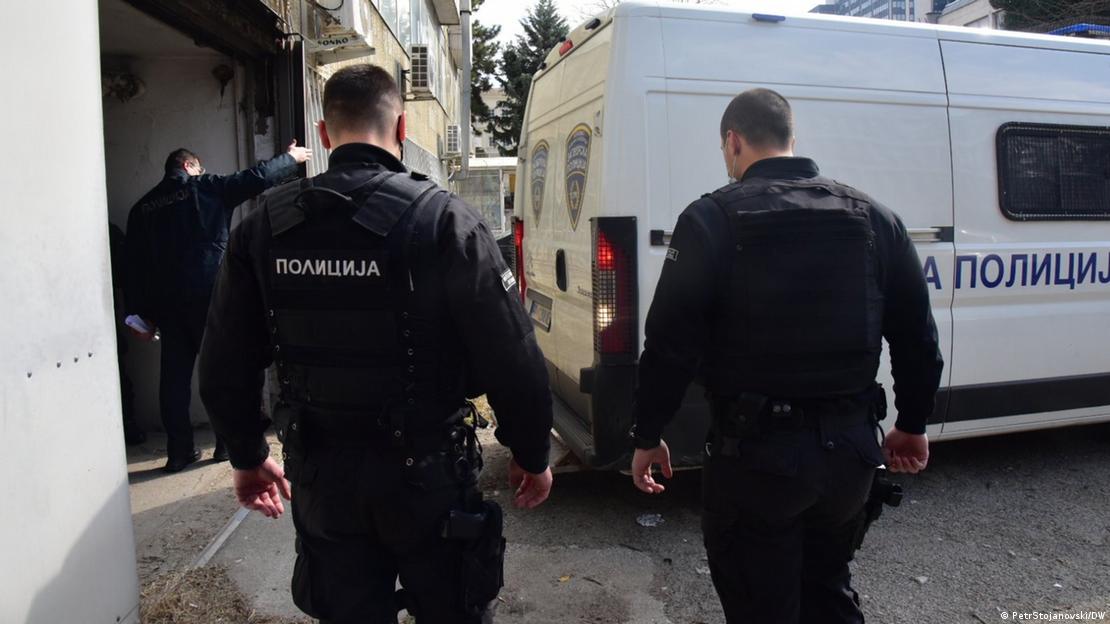 Двајца македонски полицајци одат кон бело комбе на кое пишува Полиција Двајца македонски полицајци одат кон бело комбе на кое пишува Полиција