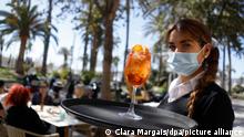 17.03.2021, Palma, Fiorella, die im Restaurant Enco als Kellnerin arbeitet, trägt einen Cocktail auf dem Tablett. Fluggesellschaften planen zu den Osterferien weitere Flüge aus Deutschland nach Mallorca aufgrund der starken Nachfrage. +++ dpa-Bildfunk +++