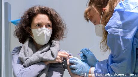 A woman receiving a COVID vaccine at a vaccination center in Berlin