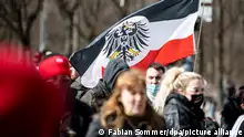 Teilnehmer einer Demonstration von Rechtsextremisten und sogenannten «Reichsbürgern» laufen mit einer Flagge aus dem Kaiserreich die Straße des 17. Juni entlang.