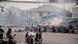 Firecrackers explode as protestors take cover behind a barricade during a demonstration against the military coup Firecrackers explode as protestors take cover behind a barricade during a demonstration against the military coup