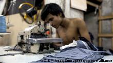 June 21, 2017 - Dhaka, Dhaka, Bangladesh - June 21, 2017 Dhaka, Bangladesh - Bangladeshi labour work with a tiny space stitches denim jeans for local market in a local garments shop at Dhaka
