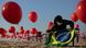 Mulher segura bandeira do Brasil em meio a cruzes e balões vermelhos na praia em protesto sobre condução da pandemia Mulher segura bandeira do Brasil em meio a cruzes e balões vermelhos na praia em protesto sobre condução da pandemia