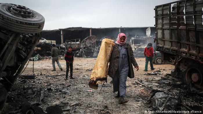 Syrians inspecting the damage left by an air raid near the border with Turkey