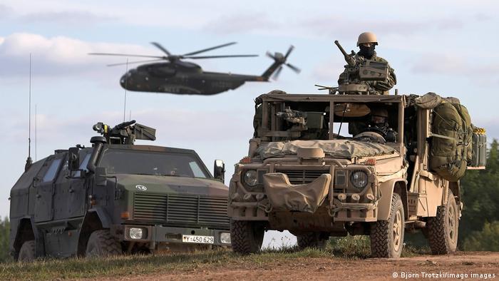 armored vehicles and helicopter in action
