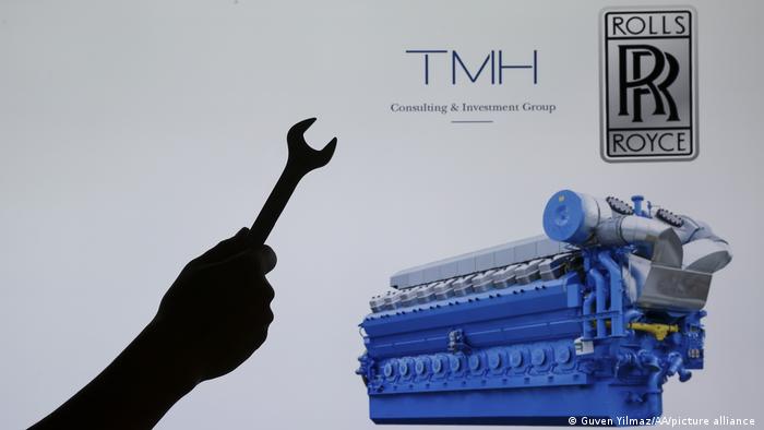 Silhouette of a hand holding wrench, an engine, TMH Company logo, and Rolls Royce Company Logo. 