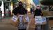 Women hold paper bags with protest slogans in Greek. The women are wearing face masks and traditional Greek dress Women hold paper bags with protest slogans in Greek. The women are wearing face masks and traditional Greek dress