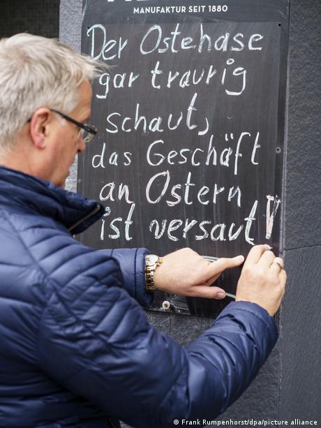 Ein Cafe-Besitzer in Friedberg beim Beschriften seiner Preistafel