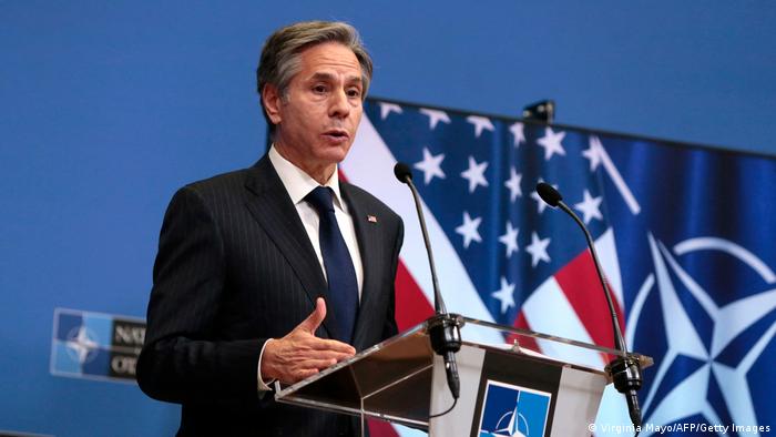 US-Außenminister Antony Blinken im NATO-Hauptquartier in Brüssel am Rednerpult mit NATO-Logo. Im Hintergrund eine US- und eine NATO-Flagge