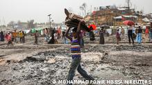 A Rohingya refugee boy carries household stuff that remained after a massive fire broke out two days ago in Cox's Bazar, Bangladesh, March 24, 2021. REUTERS/Mohammad Ponir Hossain