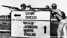 FILE - In this Dec. 8, 1971, file photo, Indian troops stand guard at a road crossing to Dacca after capturing Jessore town, East Pakistan. Bangladesh is celebrating 50 years of independence this year. (AP Photo, File)