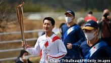 *** Dieses Bild ist fertig zugeschnitten als Social Media Snack (für Facebook, Twitter, Instagram) im Tableau zu finden: Fach „Images“ —> Weltspiegel/Bilder des Tages *** 25.03.21 ***
Japanese torchbearer Ryo Matsumoto (L), a student of Nippon Sport Science University, carries an Olympic torch during the first day of Tokyo 2020 Olympic Games torch relay in the town of Naraha, Fukushima Prefecture on March 25, 2021. (Photo by CHARLY TRIBALLEAU / AFP) (Photo by CHARLY TRIBALLEAU/AFP via Getty Images)