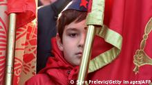 A child stands behind a flag as he attends a ceremony held to mark the unveiling of a statue of late Yugoslavia leader Josip Broz Tito, in Podgorica, Montenegro, on December 19, 2018. - Montenegro unveiling a statue of the late Yugoslav leader Josip Broz Tito reverses a trend in many neighbouring countries to remove his name and monuments from cities after the fall of the communist state in the 1990s. (Photo by SAVO PRELEVIC / AFP) (Photo credit should read SAVO PRELEVIC/AFP via Getty Images)