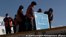 Airport employees unload the first shipment of Russia's Sputnik V COVID-19 vaccine after it arrived at the international airport in El Alto, Bolivia, Thursday, Jan. 28, 2021. (AP Photo/Juan Karita)
