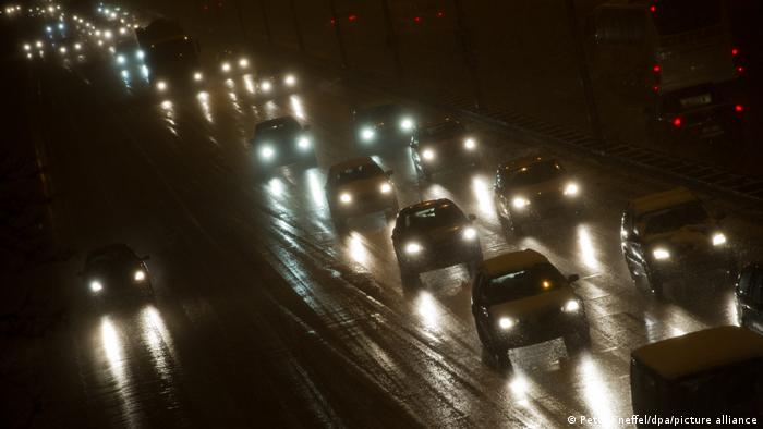 Autos auf verschneiter Straße im Dunkeln