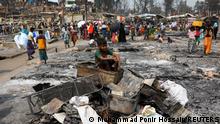 A Rohingya refugee boy sits on a stack of burnt materials after a fire broke out earlier this week and destroyed thousands of shelters at the Balukhali refugee camp in Cox's Bazar, Bangladesh, March 24, 2021. REUTERS/Mohammad Ponir Hossain SEARCH BALUKHALI FAMILY FOR THIS STORY. SEARCH WIDER IMAGE FOR ALL STORIES