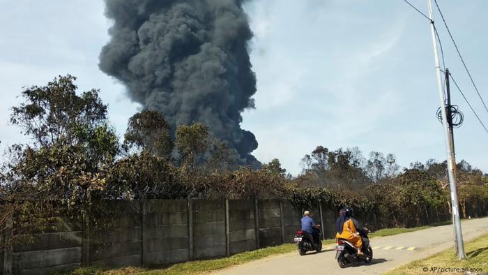 Pengendara melintas saat asap tebal mengepul dari api yang melanda kilang Pertamina Balongan