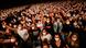 Masked audience members raise hands during the concert Masked audience members raise hands during the concert
