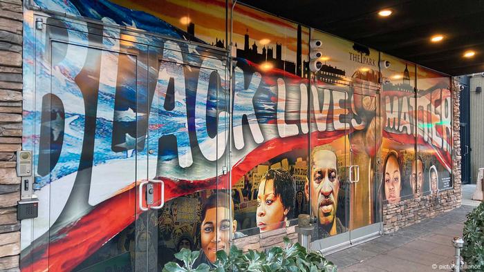 A mural in Washington, DC.: A black fist holds up a U.S. flag that reads Black Lives Matter.