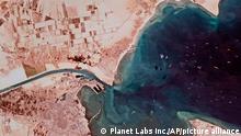 This satellite photo from Planet Labs Inc. shows the Ever Given cargo ship stuck in Egypt's Suez Canal as a mass of ships wait in the Red Sea to pass through the waterway Monday, March 29, 2021. Engineers on Monday partially refloated the colossal container ship that continues to block traffic through the Suez Canal, authorities said, without providing further details about when the vessel would be set free. (Planet Labs Inc. via AP)