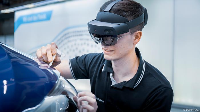 Un mécanicien Merzedes-Benz porte des lunettes de réalité augmentée lors de la réparation du véhicule
