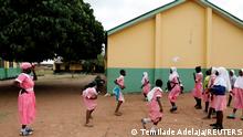 Shade Ajayi, 50, looks at her classmates as they play outside after class at Ilorin Grammar School, Kwara state, March 25, 2021. REUTERS/Temilade Adelaja SEARCH ADELAJA PUPIL FOR THIS STORY. SEARCH WIDER IMAGE FOR ALL STORIES