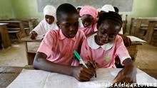 Quareebullahi Ajenifuja, 12, and Joy Adeniji, 12, take notes together during class at Ilorin Grammar school, in Ilorin, Kwara state, Nigeria, March 26, 2021. REUTERS/Temilade Adelaja SEARCH ADELAJA PUPIL FOR THIS STORY. SEARCH WIDER IMAGE FOR ALL STORIES