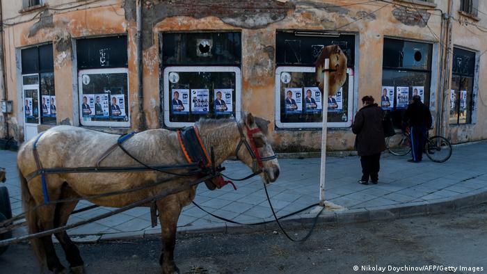 Предизборни плакати в България и кон, вързан на пътен знак