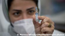 Medical personnel holds an ampule of the Russian Sputnik-V, The first registered vaccine against COVID-19, for photographer in Golestan hospital in the city of Ahvaz 817Km (508 miles) south of Tehran in Khouzestan province on March 14, 2021. (Photo by Morteza Nikoubazl/NurPhoto)