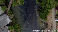 An aerial view shows people fishing from a wooden bridge at the Pisang Batu river, which flows through a densely populated area and is polluted by domestic waste, in Bekasi, on the outskirts of Jakarta, Indonesia, March 16, 2021. Pisang Batu river, on the outskirts of Jakarta, made national headlines in 2019 after plastic garbage and organic waste from nearby households completely covered its surface stretching 1.5 kilometres. The river has fewer waste after several cleanup operations, but the water is black, emitting a strong odour. Picture taken with a drone. REUTERS/Willy Kurniawan SEARCH GLOBAL WATER FOR THIS STORY. SEARCH WIDER IMAGE FOR ALL STORIES