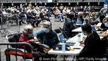 29.03.21 *** People register upond their arrival at the Palais des Sports venue in Lyon, hosting a Covid-19 vaccination centre, on March 29, 2021 as France faces a new wave of infections to the novel coronavirus. (Photo by JEAN-PHILIPPE KSIAZEK / AFP) (Photo by JEAN-PHILIPPE KSIAZEK/AFP via Getty Images)