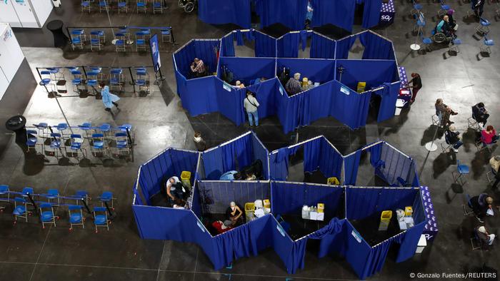 Vista aérea de cum centro de vacinação. Salas são improvisadas com cortinas.