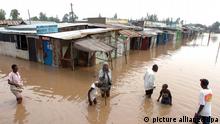 Villagers go about their business in a flooded market centre