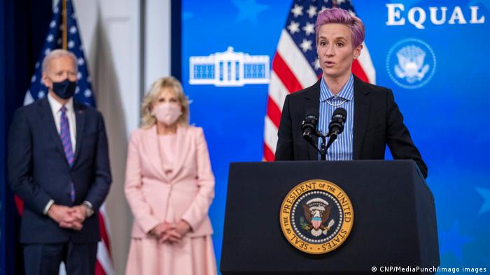 Megan Rapinoe spricht am Equal Pay Day im Weißen Haus, im Hintergrund Präsident Joe Biden und seine Frau Jill. 