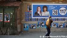 A man walks past a wall with election posters of the ruling centre-right GERB party