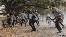 Protesters react during a crackdown by security forces on demonstrations against the military coup in Mandalay, Myanmar