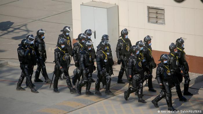 Security forces stand guard before the transfer of mummies